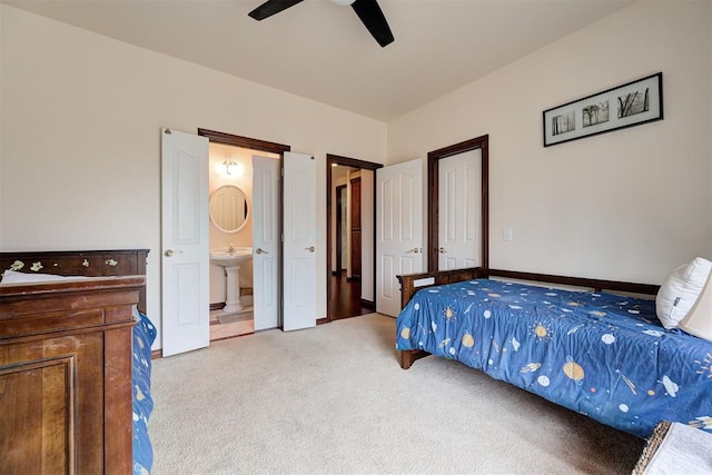 carpeted bedroom with connected bathroom, sink, and ceiling fan