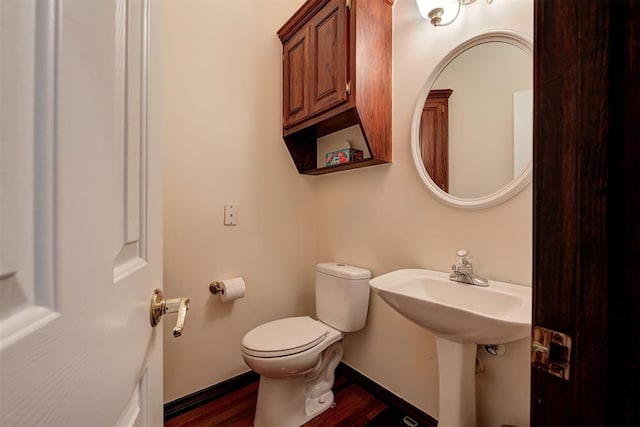 bathroom with hardwood / wood-style flooring and toilet