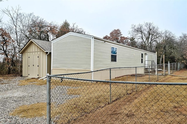 view of side of home featuring a storage shed