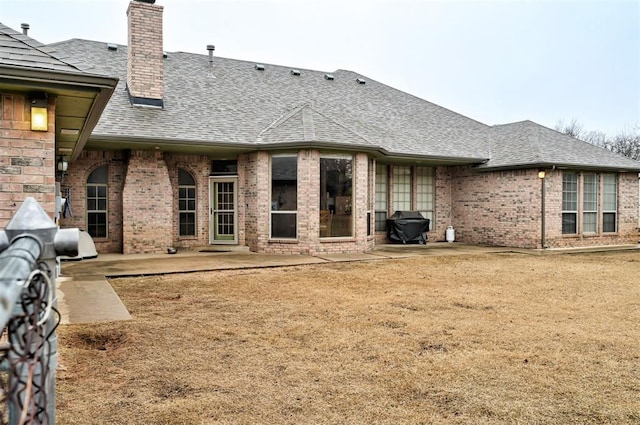 back of property featuring a patio and a lawn