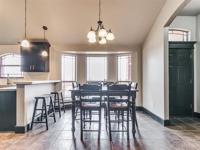 dining area featuring an inviting chandelier, lofted ceiling, and sink