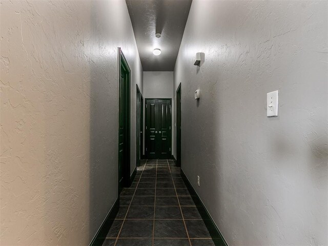 corridor featuring dark tile patterned floors