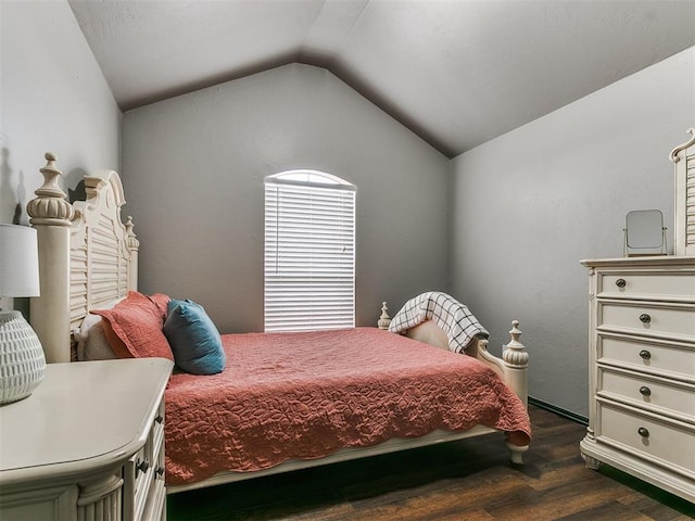 bedroom featuring dark wood-type flooring and vaulted ceiling