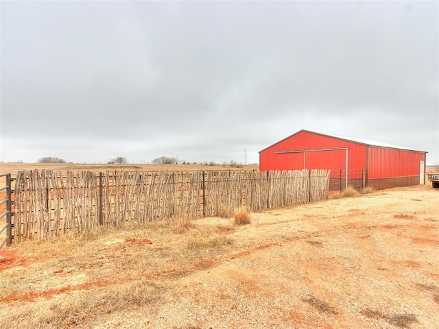 view of yard with an outdoor structure and a rural view