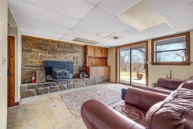 living room featuring a drop ceiling and concrete flooring