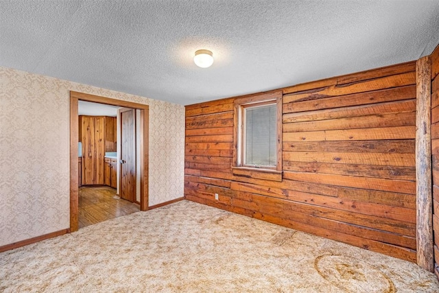 empty room featuring light colored carpet and a textured ceiling