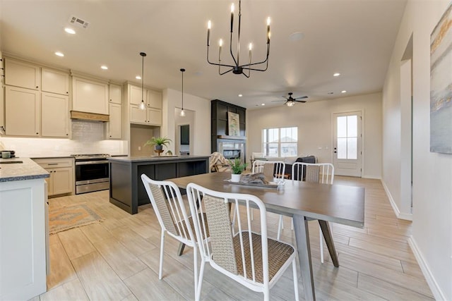 dining room featuring a fireplace and ceiling fan