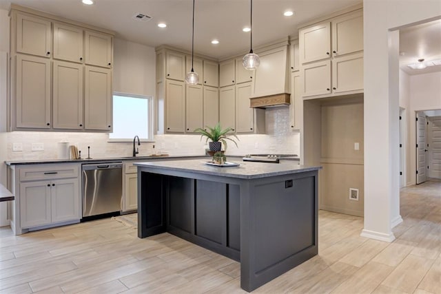 kitchen with tasteful backsplash, decorative light fixtures, a center island, light hardwood / wood-style flooring, and dishwasher