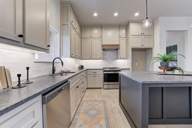 kitchen featuring pendant lighting, stainless steel appliances, gray cabinets, and sink