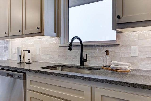 kitchen featuring dishwasher, sink, and backsplash