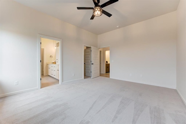 unfurnished bedroom featuring ceiling fan, light carpet, and ensuite bath