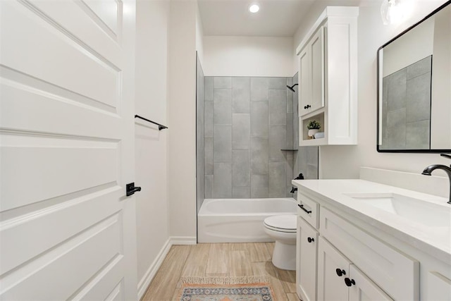 full bathroom with wood-type flooring, toilet, tiled shower / bath combo, and vanity