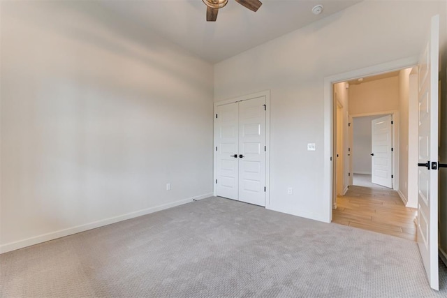 unfurnished bedroom with ceiling fan, a closet, and light carpet