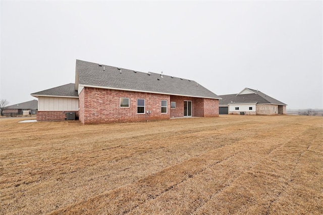 rear view of property with a yard and central AC