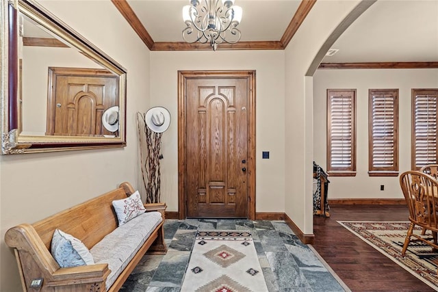 foyer entrance featuring arched walkways, a chandelier, wood finished floors, baseboards, and crown molding