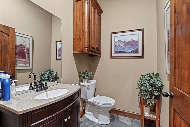 half bath with toilet, vanity, and baseboards