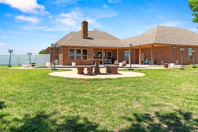 back of house with a patio area, a chimney, and brick siding