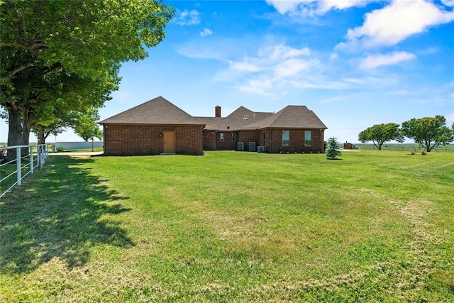 back of house featuring brick siding and a chimney
