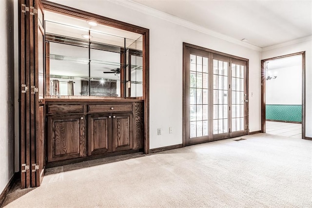 doorway with ornamental molding and light carpet