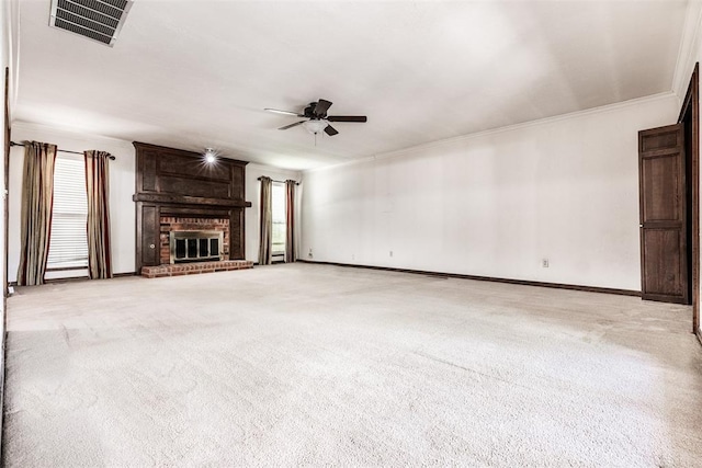 unfurnished living room with light carpet, crown molding, a fireplace, and ceiling fan