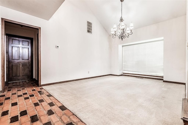 carpeted spare room featuring an inviting chandelier and high vaulted ceiling