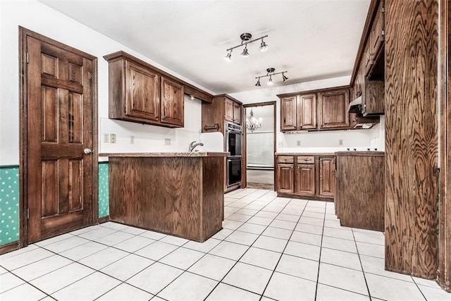 kitchen with light tile patterned flooring, dark brown cabinets, and double oven