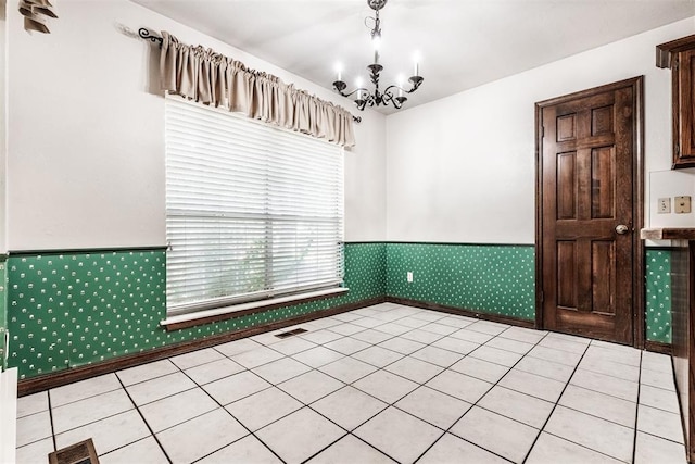 unfurnished room featuring a chandelier