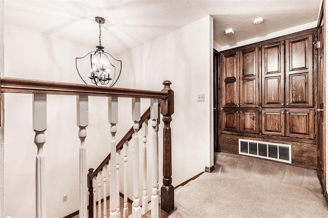 corridor with carpet flooring and a notable chandelier