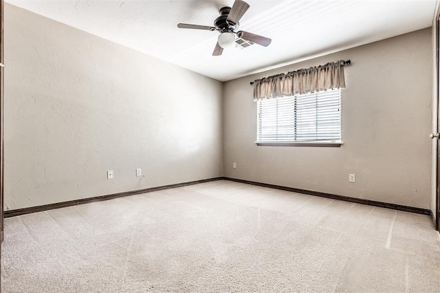 carpeted spare room featuring ceiling fan