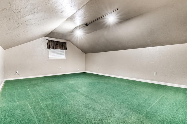 additional living space featuring vaulted ceiling, carpet floors, and a textured ceiling