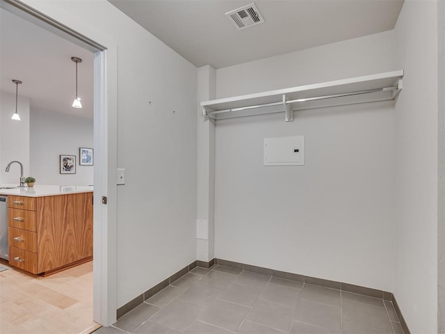 clothes washing area with sink and light tile patterned floors