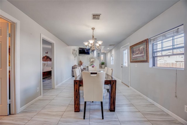 dining room featuring a chandelier and light tile patterned floors