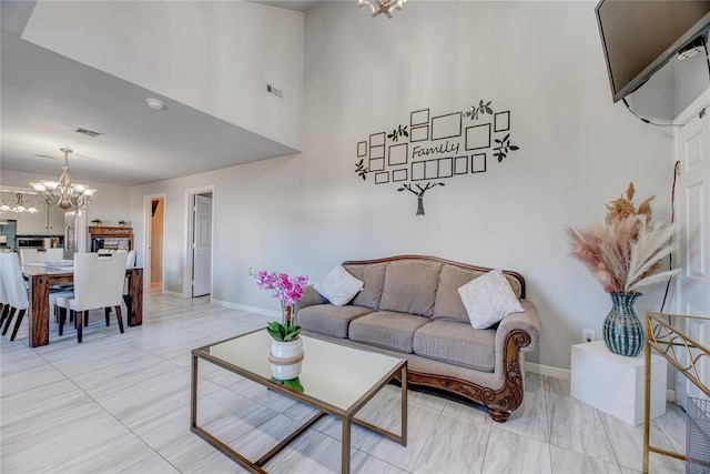 living room featuring an inviting chandelier and a towering ceiling