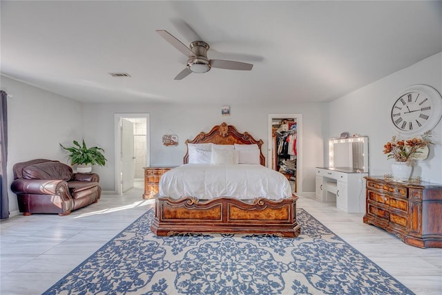 bedroom with a spacious closet, ensuite bath, a closet, and ceiling fan