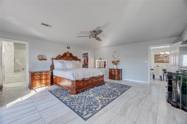 bedroom featuring a walk in closet, connected bathroom, ceiling fan with notable chandelier, and a closet