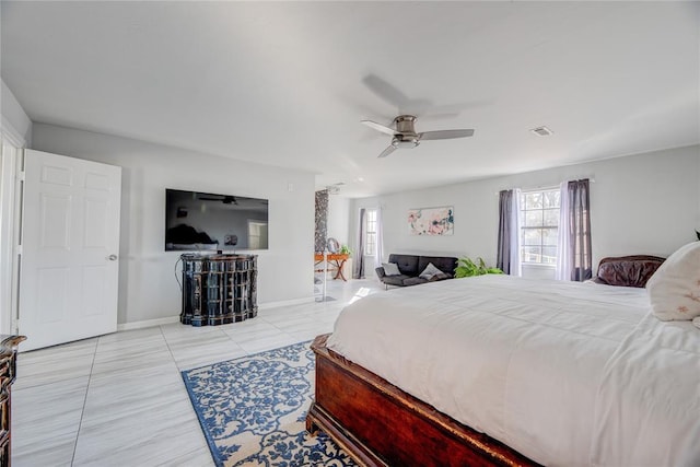 bedroom featuring ceiling fan, multiple windows, and light tile patterned floors