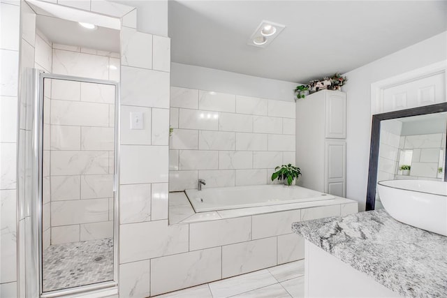 bathroom featuring shower with separate bathtub and vanity