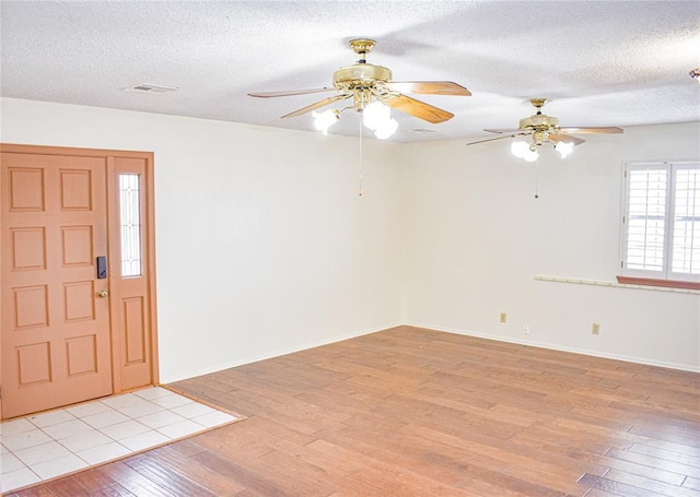 entryway with light hardwood / wood-style flooring and a textured ceiling