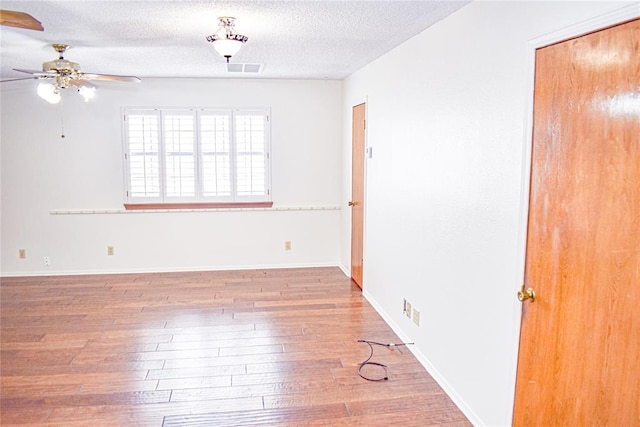 unfurnished room featuring ceiling fan, wood-type flooring, and a textured ceiling