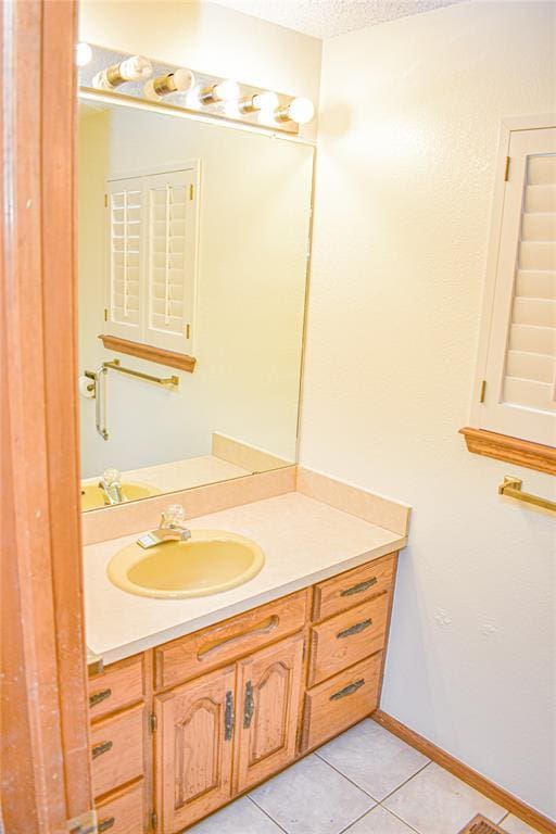 bathroom with tile patterned flooring, vanity, and a textured ceiling