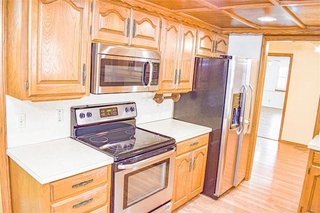 kitchen featuring coffered ceiling, light hardwood / wood-style flooring, and stainless steel appliances