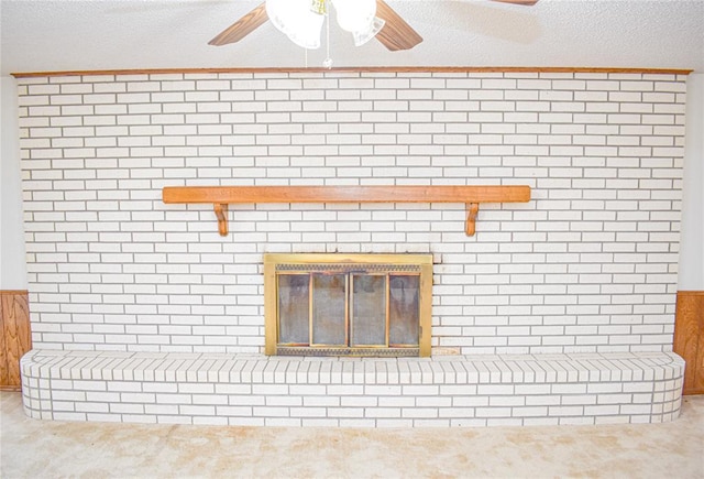 room details with ceiling fan, a brick fireplace, carpet, and a textured ceiling