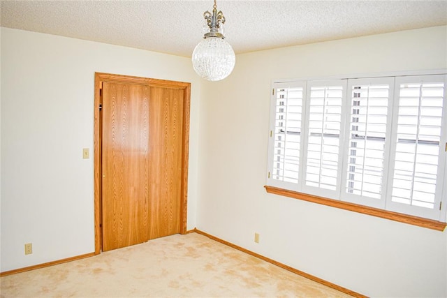 carpeted empty room with a textured ceiling