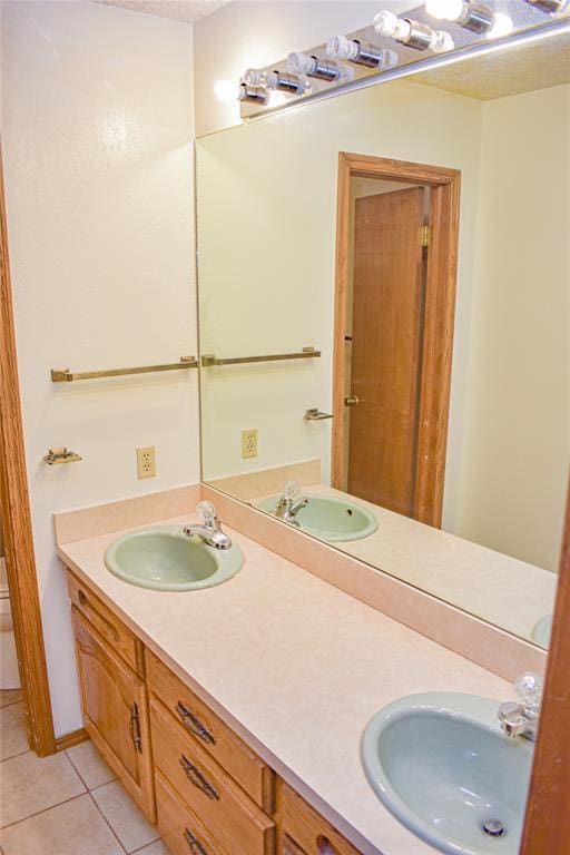 bathroom featuring tile patterned flooring, vanity, a textured ceiling, and toilet