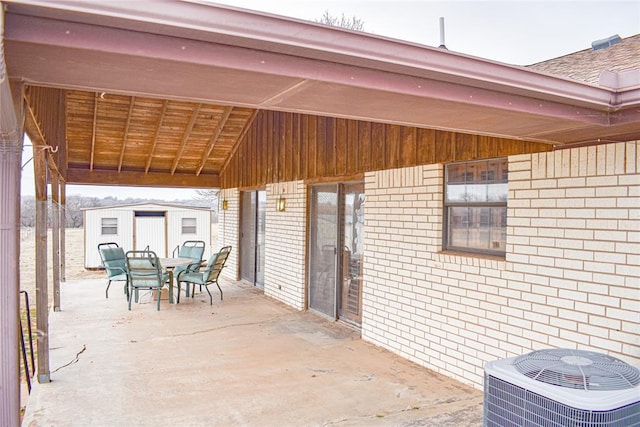 view of patio featuring cooling unit and a storage shed