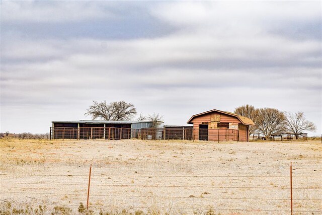 view of yard featuring a rural view and an outdoor structure