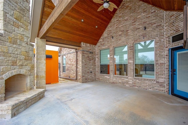 view of patio with ceiling fan and an outdoor stone fireplace