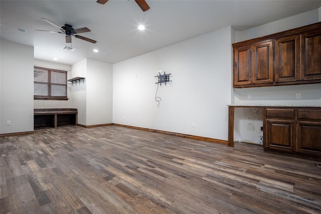 unfurnished living room with dark wood-type flooring and ceiling fan