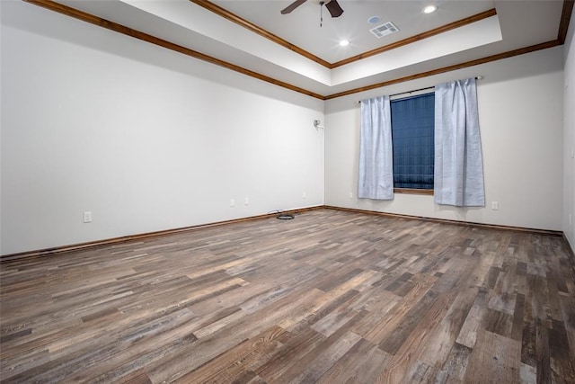 spare room with a raised ceiling, ornamental molding, wood-type flooring, and ceiling fan