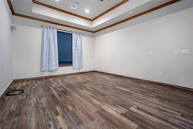 unfurnished room with a raised ceiling, crown molding, and wood-type flooring